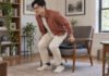 Douleur du coccyx : que peut faire l’ostéopathe et quand faut-il investiguer ? Homme se relevant prudemment d’un fauteuil équipé d’un coussin d’assise.