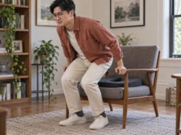 Homme se relevant prudemment d’un fauteuil équipé d’un coussin d’assise.