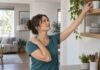 Femme levant le bras vers une étagère, illustrant les gestes du quotidien sollicitant l’épaule.