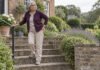 Douleur sur le côté de la hanche : pourquoi ce n’est pas toujours une bursite Femme dans un escalier, une main posée sur le côté de la hanche.