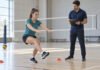 Pourquoi un sportif peut-il se sentir mieux après une séance sans être prêt à retourner au jeu ? Sportive effectuant un test fonctionnel sur une jambe sous observation avant son retour au volleyball.