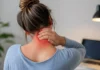 Douleur derrière la tête : 10 causes et comment la soulager Femme tenant doucement sa nuque, photographie illustrative