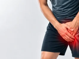 Person holding the groin with a stylized overlay of the hip region
