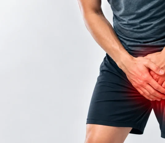 Person holding the groin with a stylized overlay of the hip region